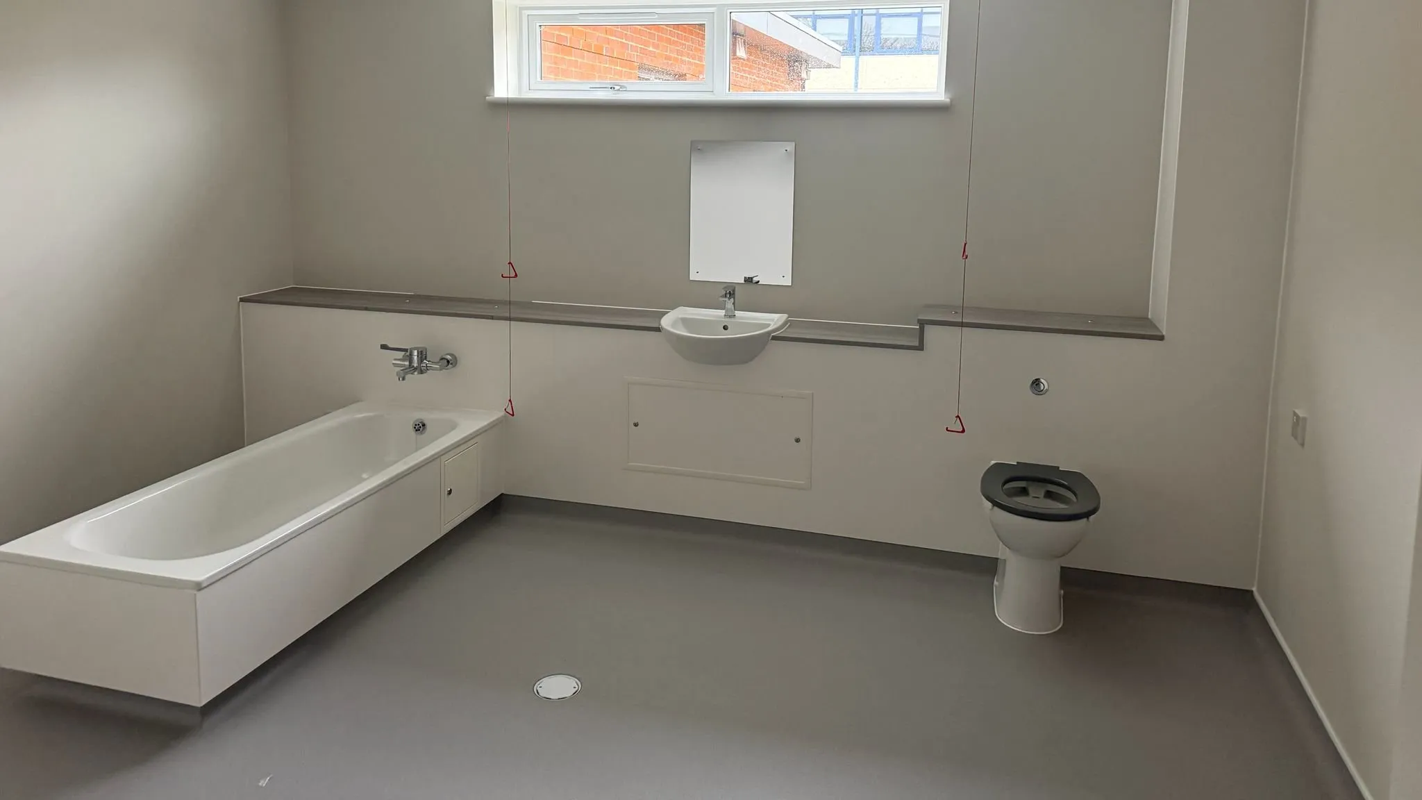 Altro Pisces safety vinyl coved up the walls in the assisted bathroom