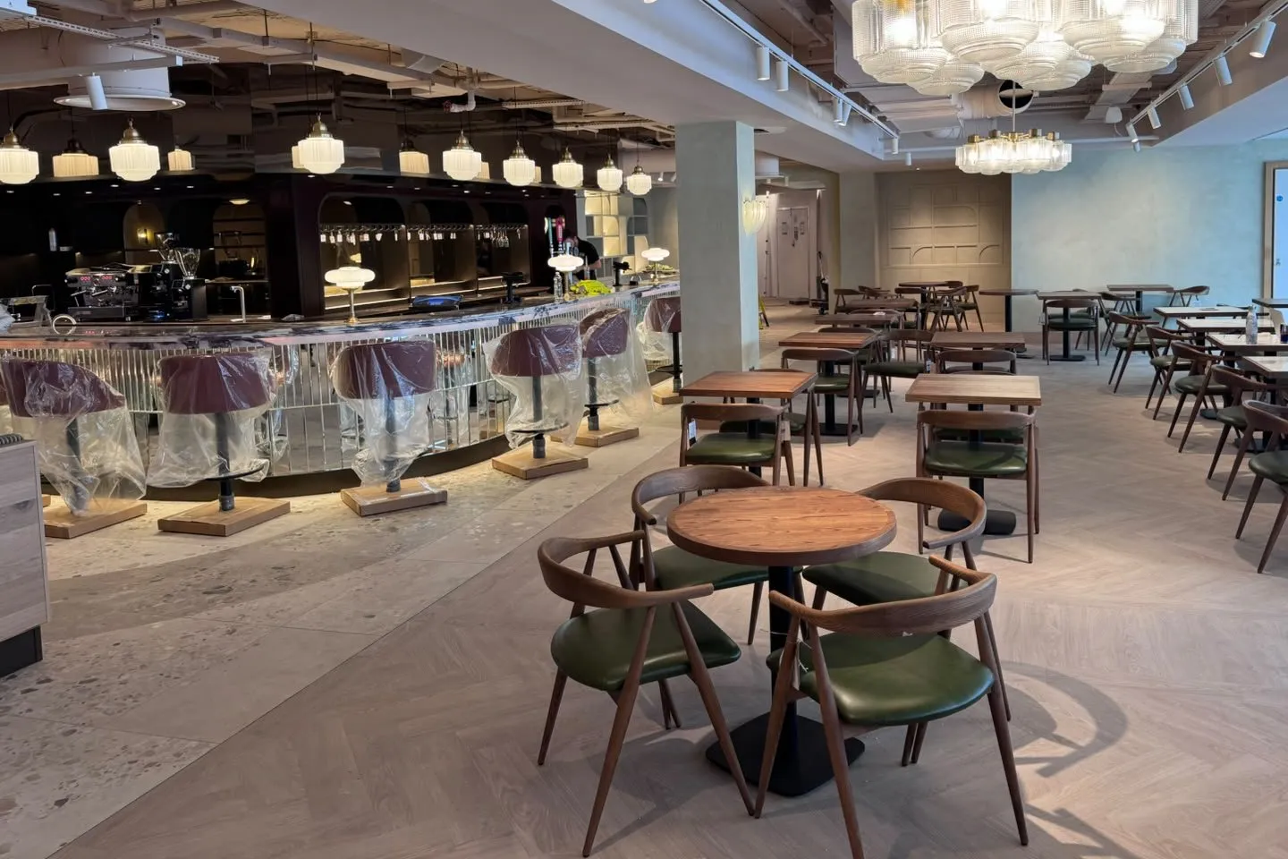 Herringbone LVT meeting the tiles in front of the central bar along a straight border plank