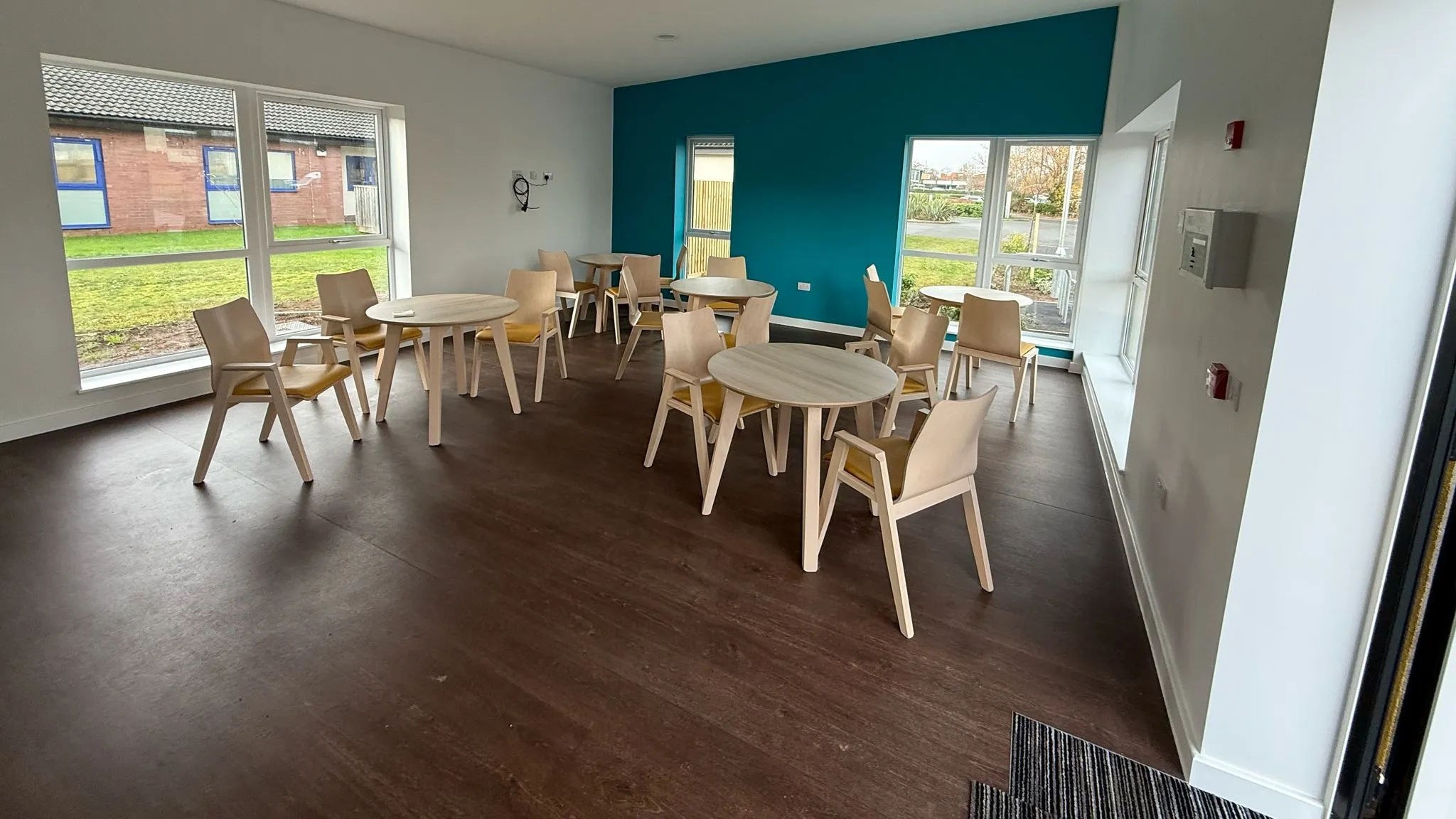 Polyflor Wood FX, a darker wood-effect safety vinyl, in the café, with Forbo Coral Welcome matting inside the door