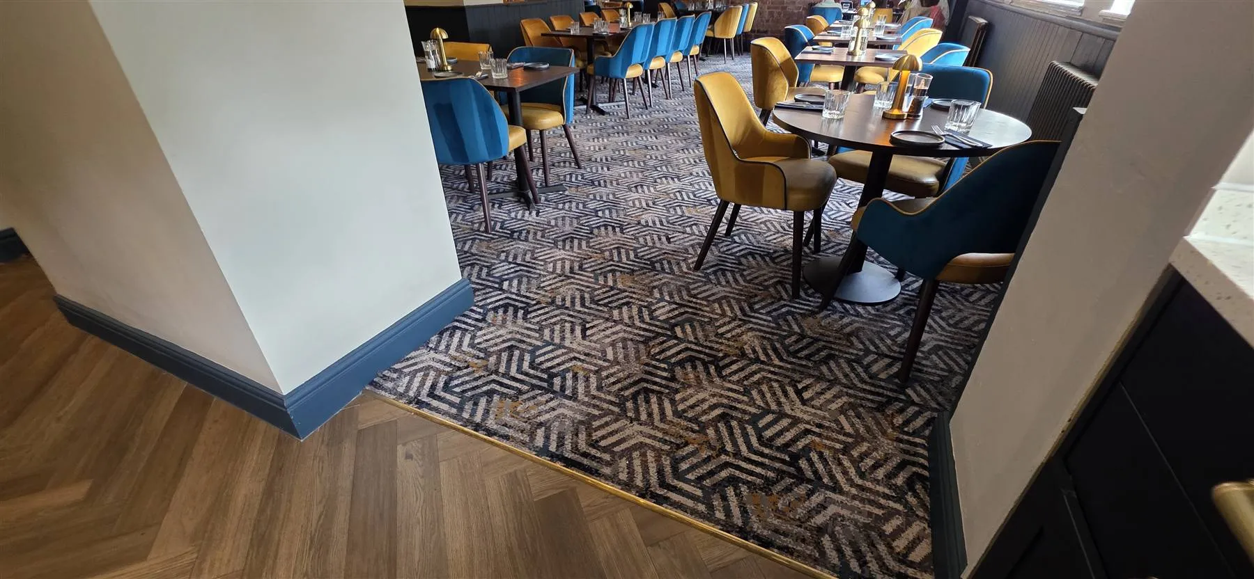 Brass trim closing the transition between the herringbone LVT and the Calderdale carpet