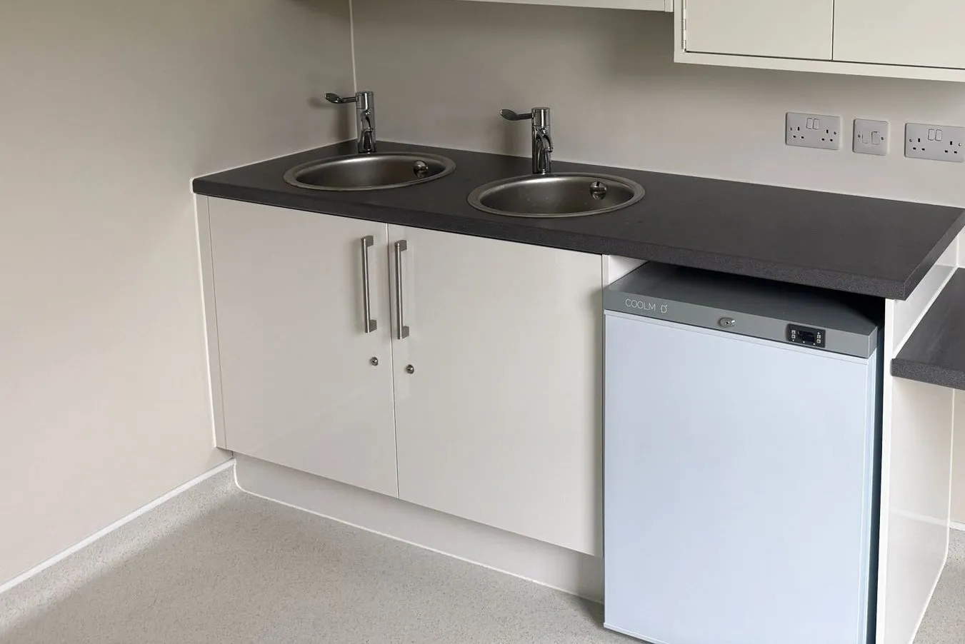 Gerflor Tarasafe Ultra safety vinyl coved up the wall in the clinic, below the twin-sink worktop