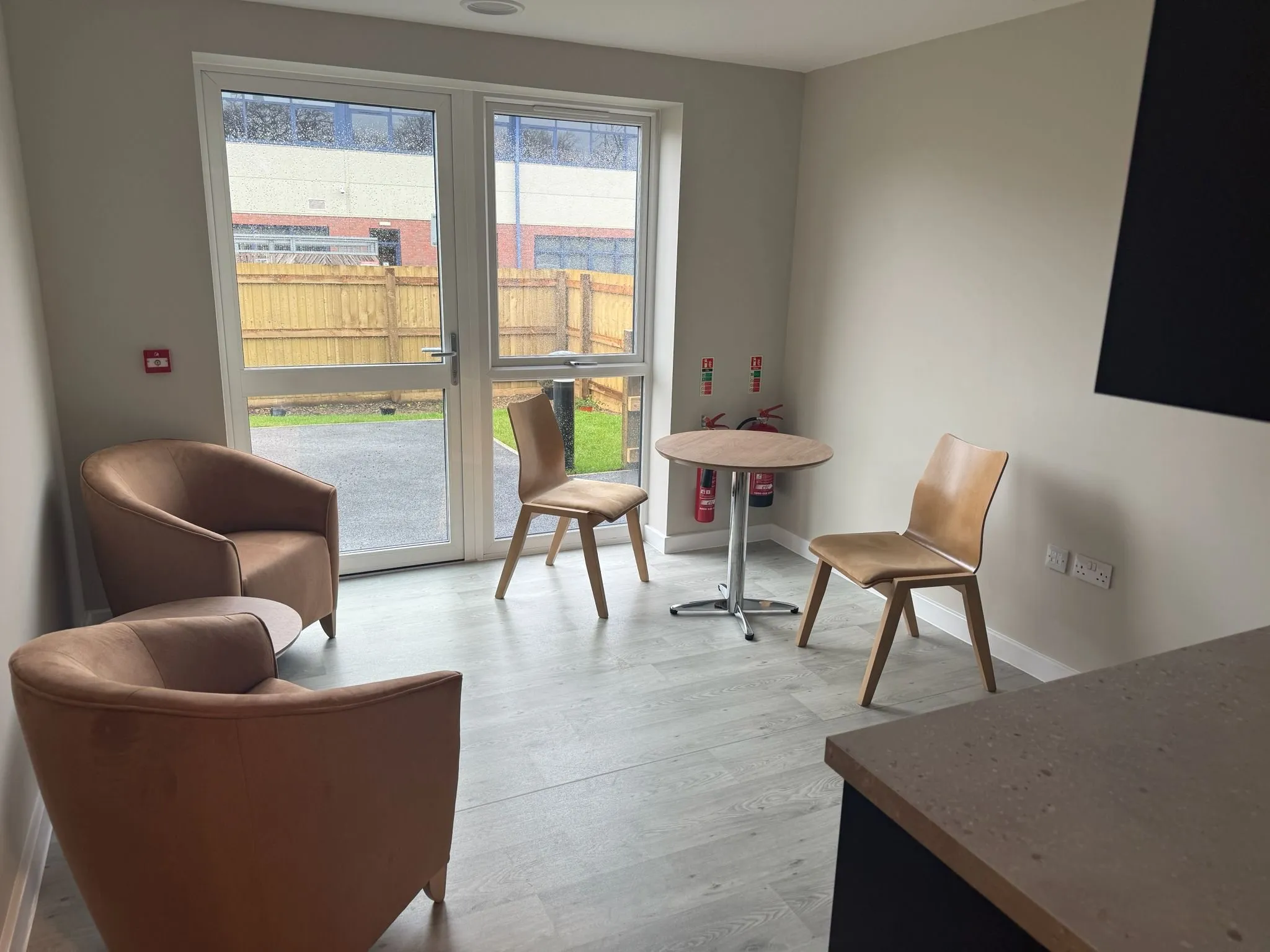 Wood-effect sheet vinyl in a day room with armchairs and garden doors
