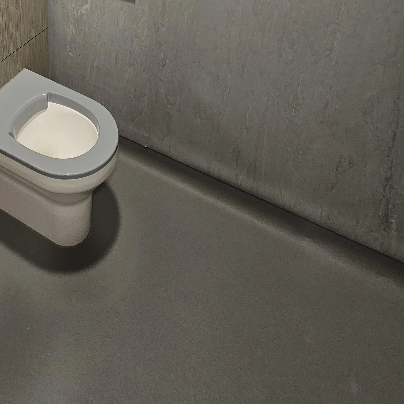 Polysafe Quattro safety flooring coved at the wall, meeting a vinyl-lined wall, in an en-suite at Cefn Carnau Hospital