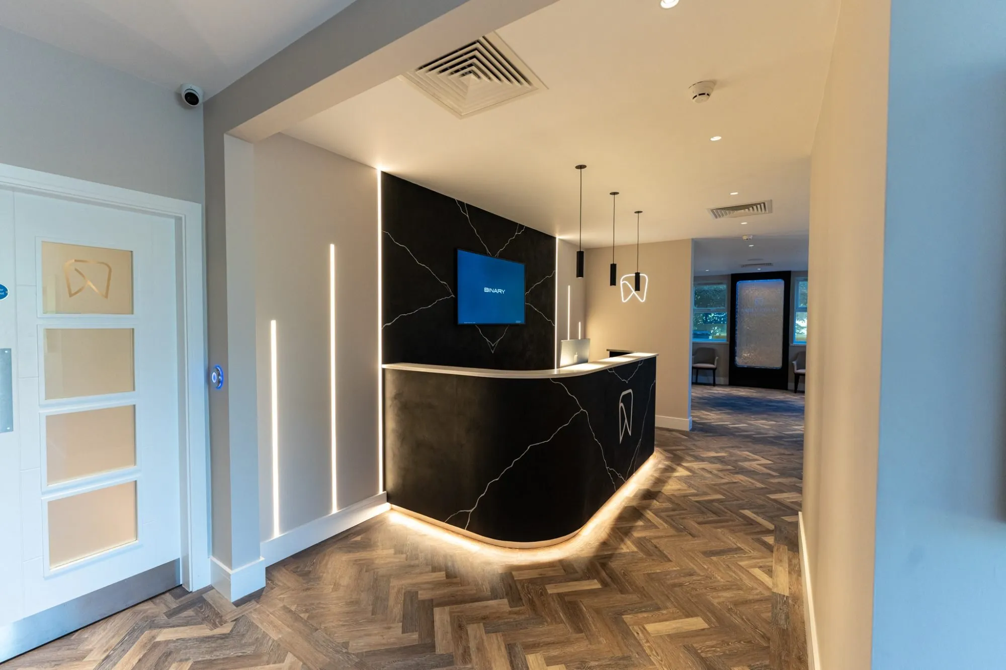Herringbone LVT through the reception at Abbey House Dental, around the curved reception desk