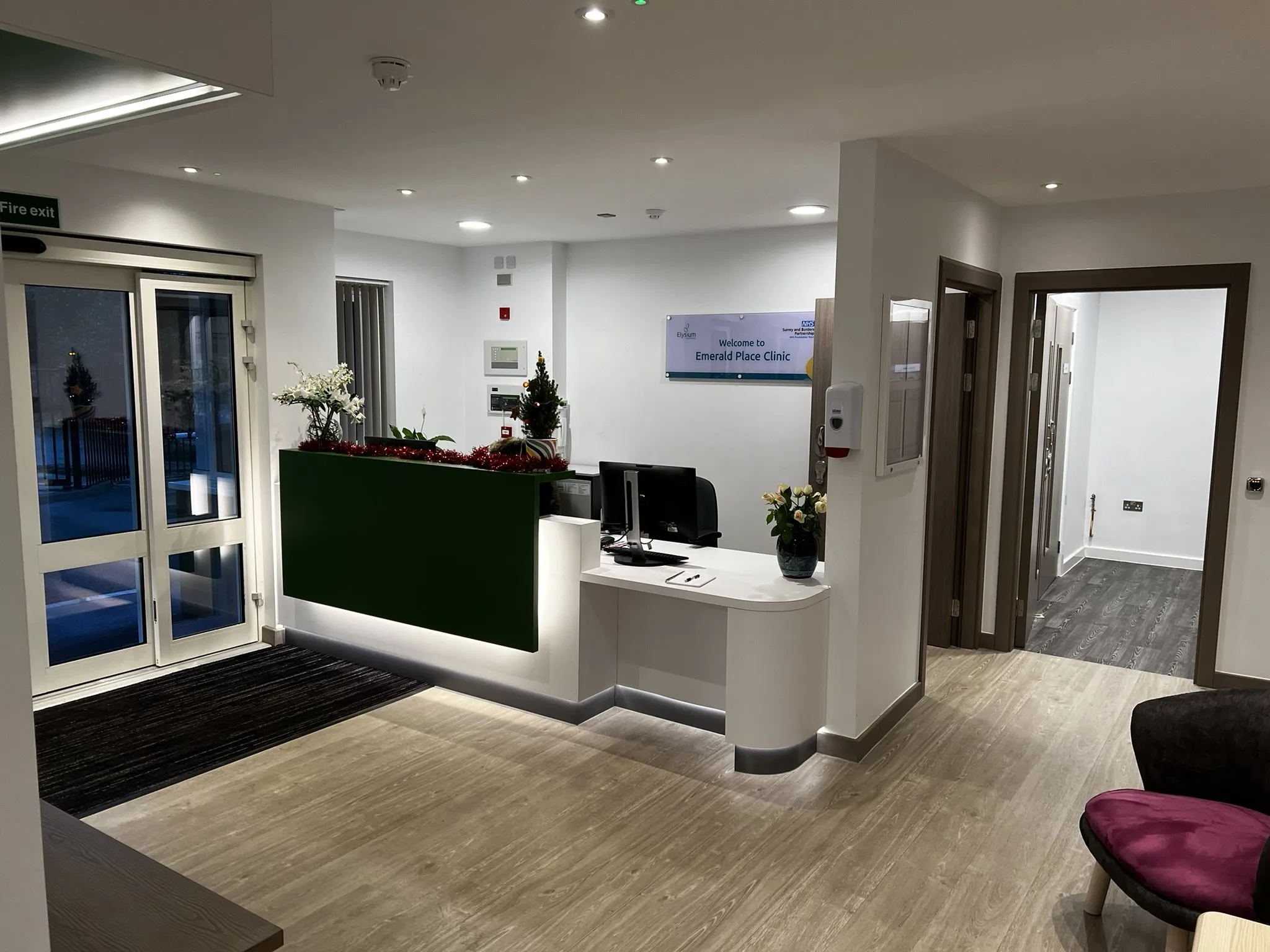 Reception at Emerald Place Clinic, with barrier matting inside the entrance doors and wood-effect flooring beyond