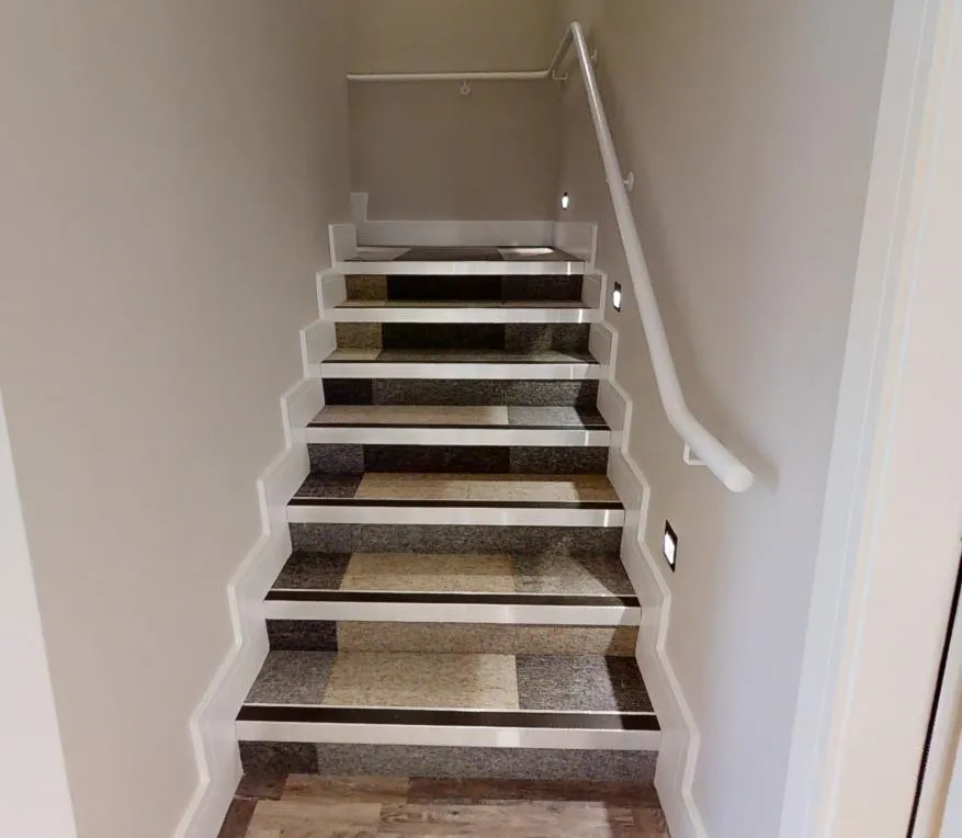 Carpet-tile stair treads with light nosings and dark contrast strips at Abbey House Dental