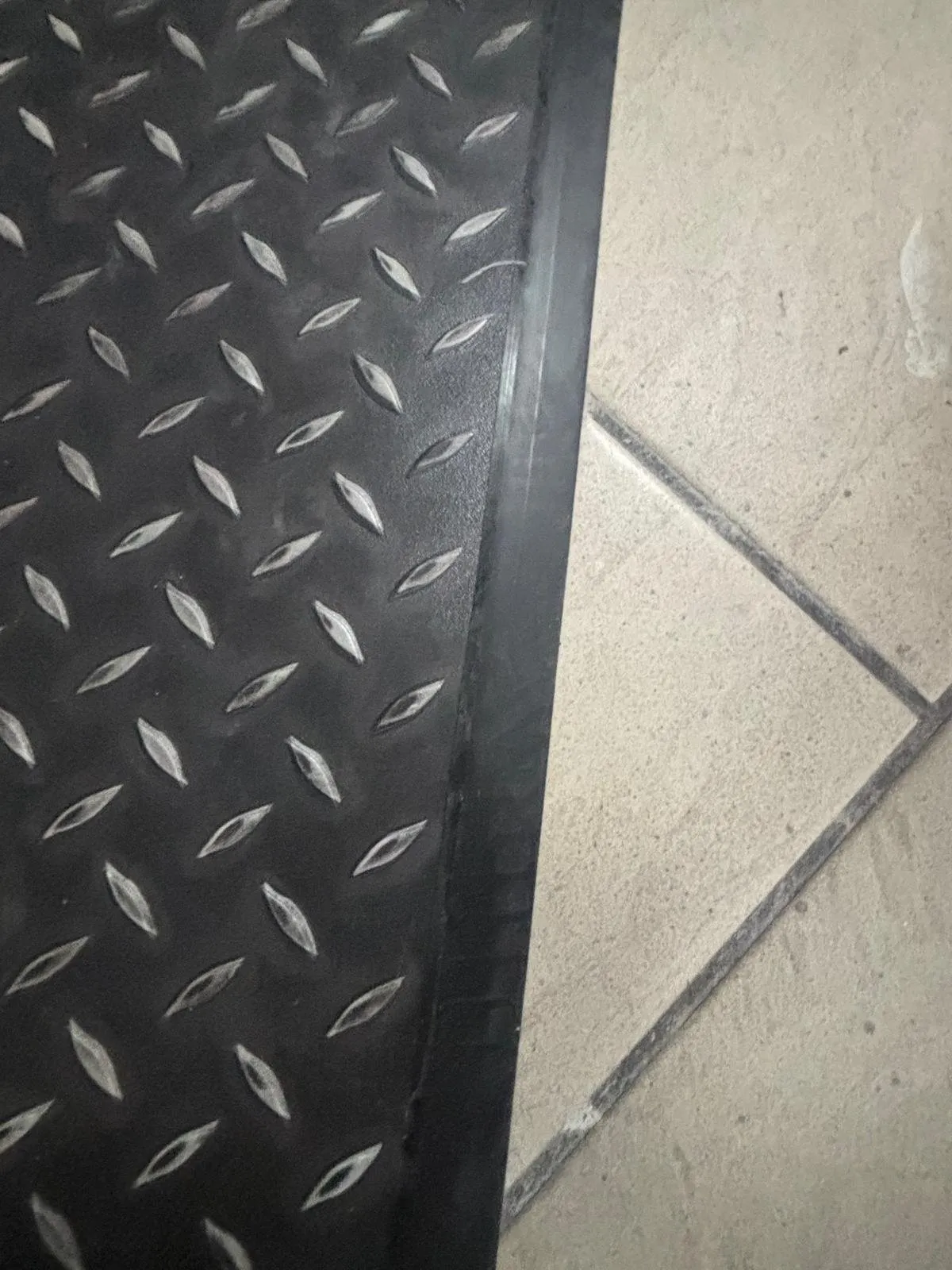 Treadplate LVT finished with a black diminishing strip against the existing ceramic floor tiles