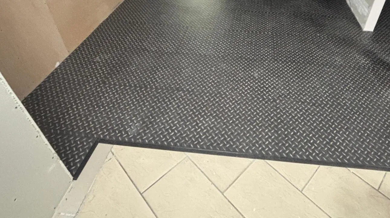 Black treadplate LVT laid up to the existing ceramic tiles at Pret A Manger, Roadchef Rownhams, while the unit was still being fitted out