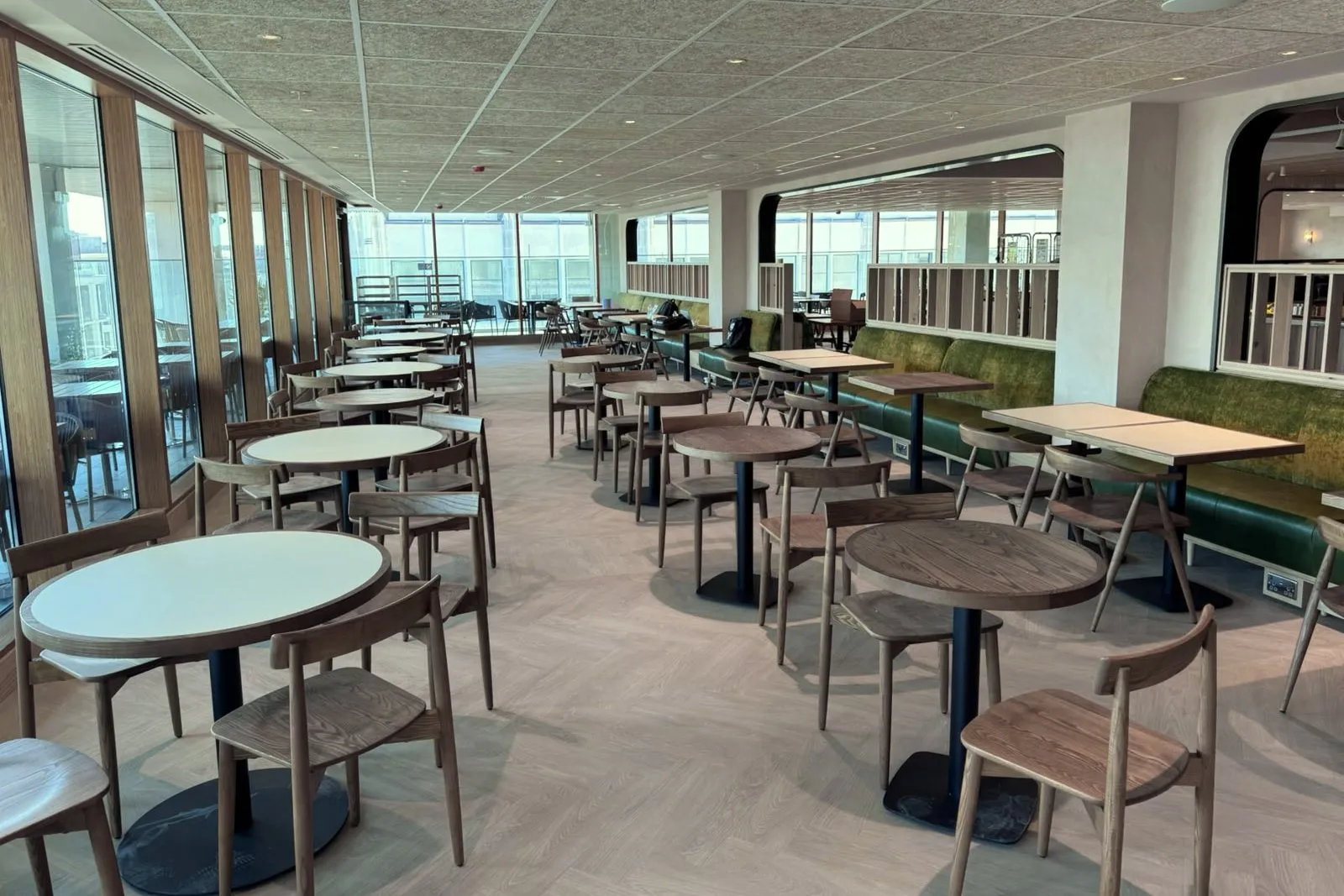 Herringbone LVT running the length of the window dining room, between the tables and the green banquettes